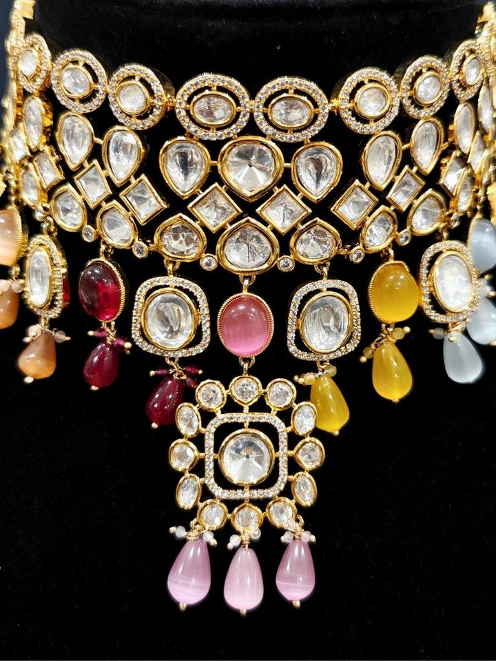 Close-up of an ornate traditional (Gold Polish) Choker jewellery set and earrings with Polki, American Diamond, Colored Stones and Tumble Beads. Wedding guest wearing a statement Polki artificial necklace for a reception party. Woman wearing trending Polki artificial jewelry for the wedding season in India.