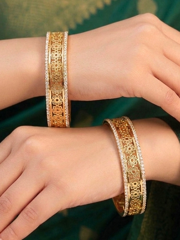 Close-up of a woman wearing an ornate traditional (Gold Polish) Bangles set with American Diamond and Filigree Work. Wedding guest look completed with lightweight artificial American Diamond bangles. Luxury artificial American Diamond bangles styled for a wedding function.