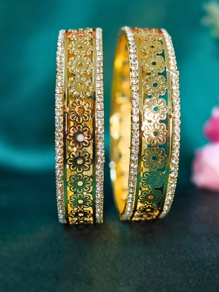 Close-up of an ornate traditional (Gold Polish) Bangles set with American Diamond and Filigree Work. Wedding guest look completed with lightweight artificial American Diamond bangles. Luxury artificial American Diamond bangles styled for a wedding function.