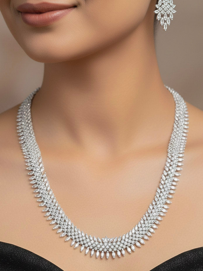 Close-up of a woman wearing an ornate Western Dimaond Silver jewellery set and earrings with American Diamond. Party wear outfit completed with a lightweight American diamond necklace. Woman styling American diamond necklace with an off-shoulder gown for a reception.