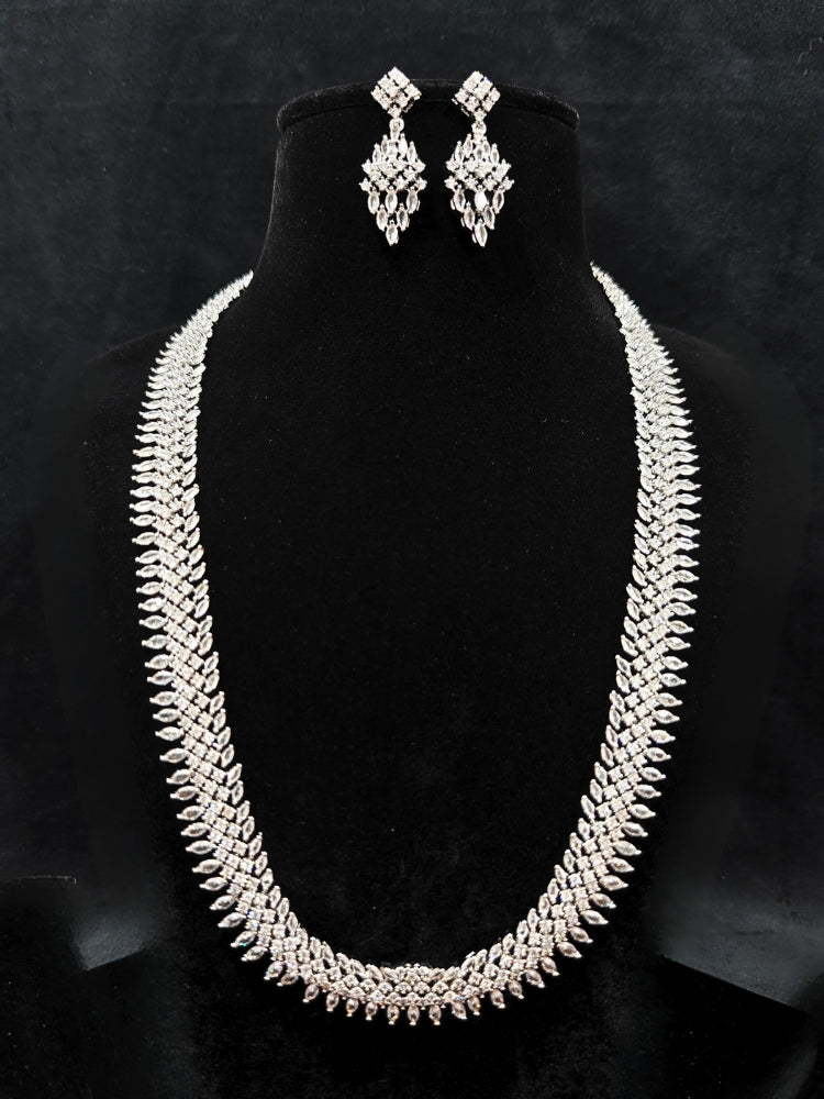 Close-up of an ornate Western Dimaond Silver jewellery set and earrings with American Diamond. Party wear outfit completed with a lightweight American diamond necklace. Styling American diamond necklace with an off-shoulder gown for a reception.