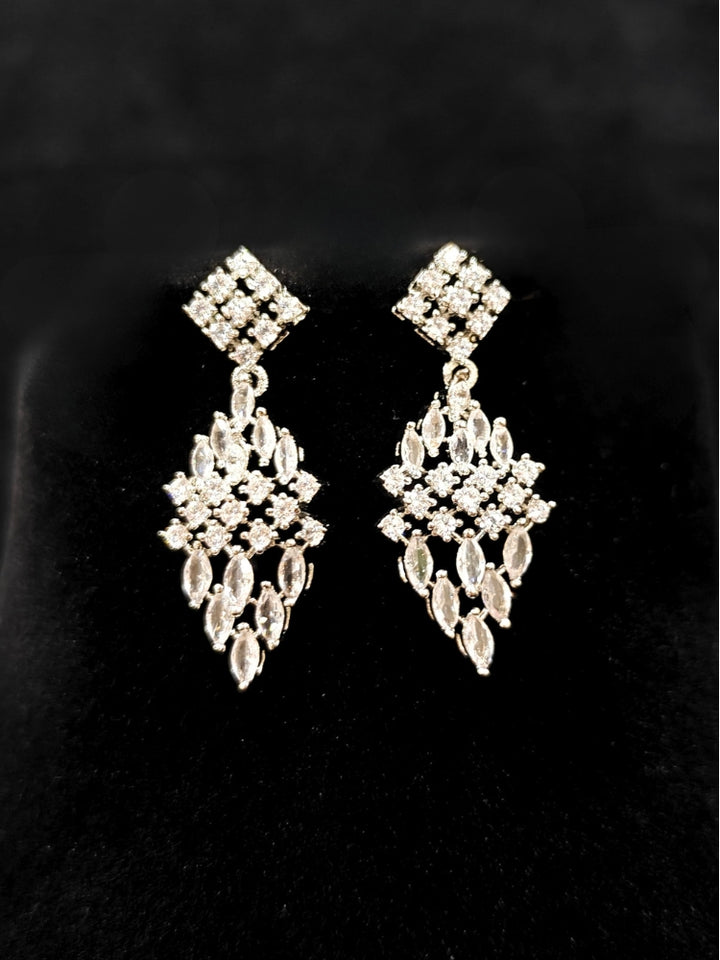 Close-up of an ornate Western Dimaond Silver jewellery set and earrings with American Diamond. Party wear outfit completed with a lightweight American diamond necklace. Styling American diamond necklace with an off-shoulder gown for a reception.