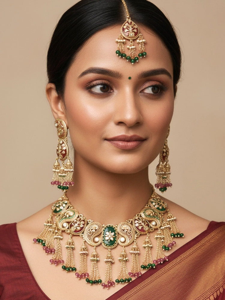 Close-up of a woman wearing an ornate traditional (Gold polish) Green and Mint Pink Collar jewellery set and earrings and maangtikka with Colored Stones, Kundan and Colored Beads. Bride wearing a colorful artificial Colored Stones set for reception night. Wedding function styling with a premium Colored Stone imitation necklace.