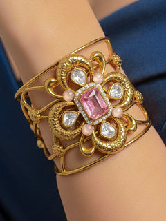 Close-up of a woman wearing an ornate traditional (Gold Polish) Mint Pink Bracelet with  American Diamonds and Colored Stones. Festive Diwali outfit paired with a colorful Colored Stone Bracelet. Wedding function styling with a premium Colored Stone imitation Bracelet.