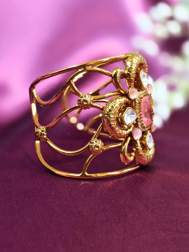 The Aziza Mint Pink Bracelet (Adjustable) showcases an intricate floral design with a large Mint Pink center stone, kundan and smaller Mint Pink colored stones, set against a rich purple background—an ideal choice for wedding jewelry.