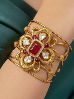 Close-up of a woman wearing an ornate traditional (Gold Polish) Red Bracelet with  American Diamonds and Colored Stones. Festive Diwali outfit paired with a colorful Colored Stone Bracelet. Wedding function styling with a premium Colored Stone imitation Bracelet.