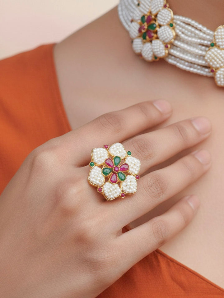 Close-up of a women wearing an ornate traditional (Bright Gold Polish) Red, Green and White Choker jewellery set and earrings and Ring with Pearls and Red & Green Colored Stones. Mehendi ceremony look completed with a handcrafted Pearl jewelry set. Woman wearing a vibrant Pearl artificial jewelry set for celebrations.