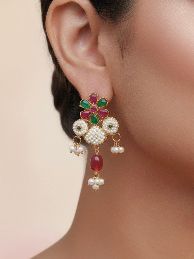 Close-up of a women wearing an ornate traditional (Bright Gold Polish) Red, Green and White Choker jewellery set and earrings and Ring with Pearls and Red & Green Colored Stones. Mehendi ceremony look completed with a handcrafted Pearl jewelry set. Woman wearing a vibrant Pearl artificial jewelry set for celebrations.