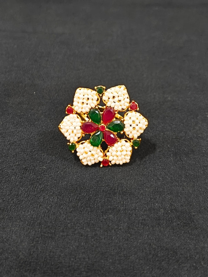 Close-up of an ornate traditional (Bright Gold Polish) Red, Green and White Choker jewellery set and earrings and Ring with Pearls and Red & Green Colored Stones. Mehendi ceremony look completed with a handcrafted Pearl jewelry set. Woman wearing a vibrant Pearl artificial jewelry set for celebrations.