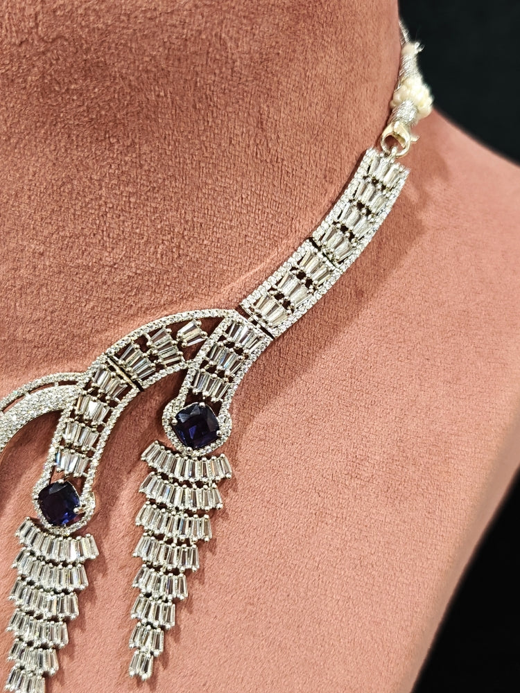 Close-up of an ornate Western Silver Diamond Collar jewellery set, earrings and Mangtikka with American Diamond and Purple Color Stone. Close-up of a Wedding, Reception look featuring a premium American diamond necklace.