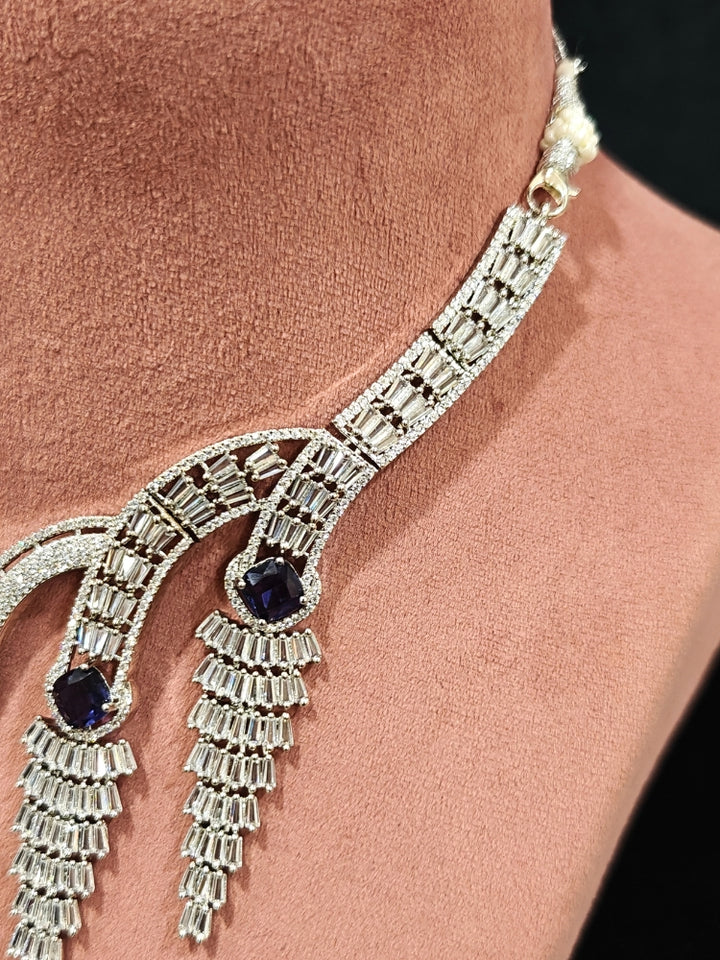 Close-up of an ornate Western Silver Diamond Collar jewellery set, earrings and Mangtikka with American Diamond and Purple Color Stone. Close-up of a Wedding, Reception look featuring a premium American diamond necklace.