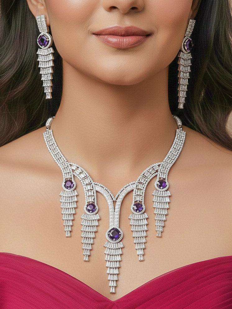 "A close-up shot of a bride wearing a stunning artificial diamond necklace with Purple colored stone and matching earrings and matching maangtikka, designed to complement bridal attire. This affordable diamond necklace set is perfect for brides seeking luxurious but cost-effective wedding jewelry in India."

