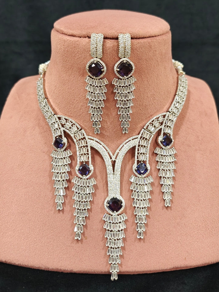 Close-up of an ornate Western Silver Diamond Collar jewellery set, earrings and Mangtikka with American Diamond and Purple Color Stone. Close-up of a Wedding, Reception look featuring a premium American diamond necklace.
