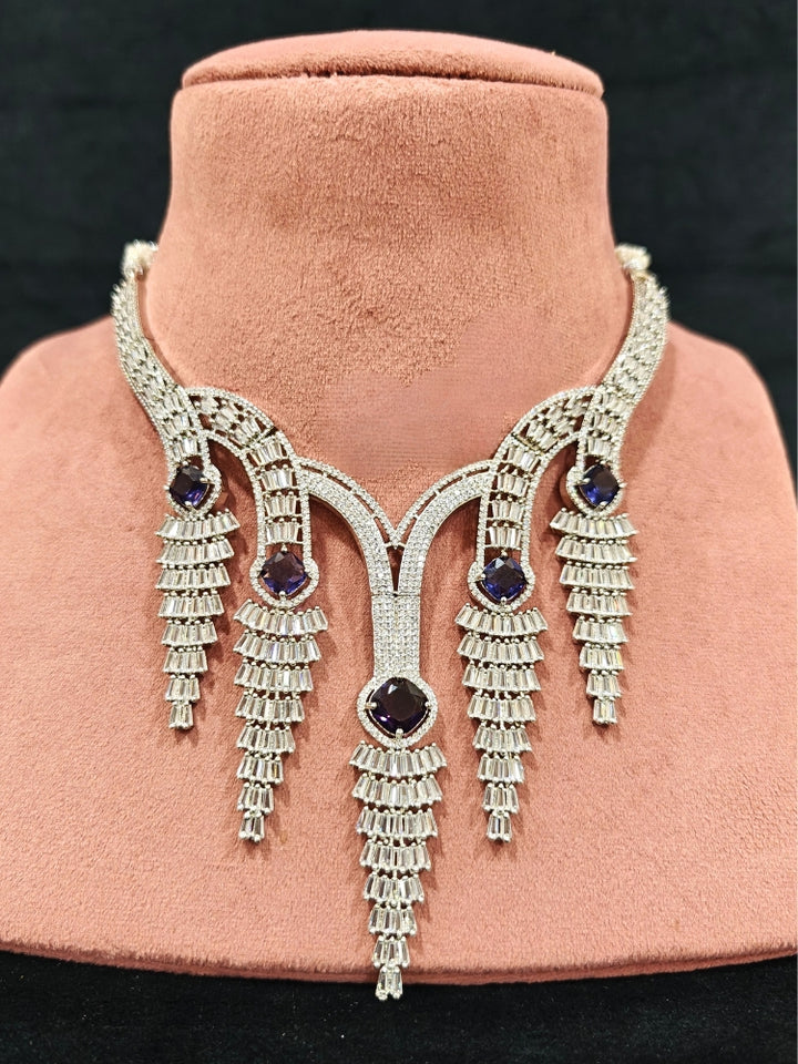 Close-up of an ornate Western Silver Diamond Collar jewellery set, earrings and Mangtikka with American Diamond and Purple Color Stone. Close-up of a Wedding, Reception look featuring a premium American diamond necklace.