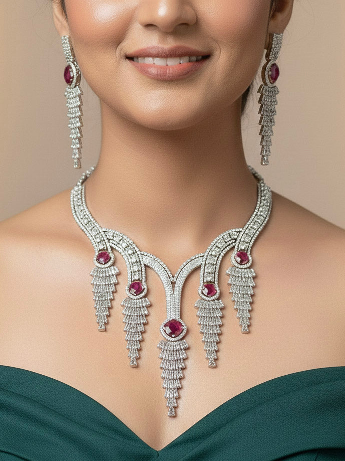 "A close-up shot of a bride wearing a stunning artificial diamond necklace with red colored stone and matching earrings and matching maangtikka, designed to complement bridal attire. This affordable diamond necklace set is perfect for brides seeking luxurious but cost-effective wedding jewelry in India."

