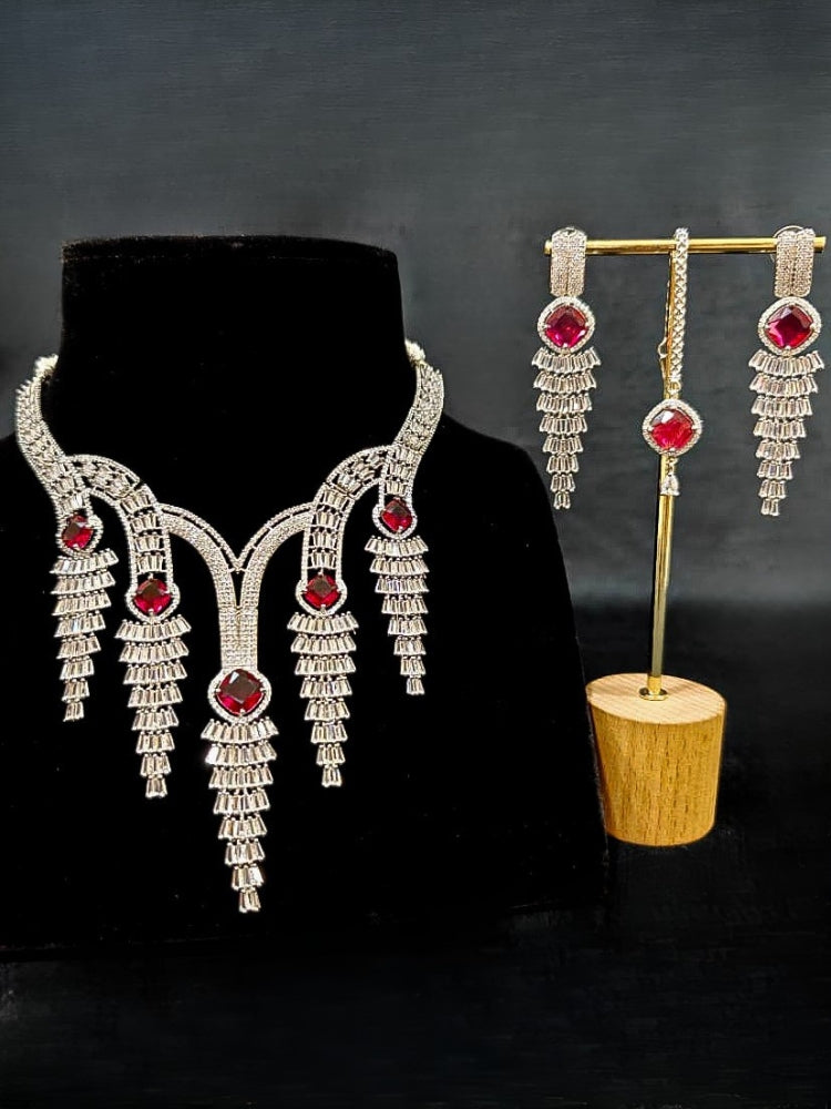 Close-up of an ornate Western Silver Diamond Collar jewellery set, earrings and Mangtikka with American Diamond and Red Color Stone. Close-up of a Wedding, Reception look featuring a premium American diamond necklace.