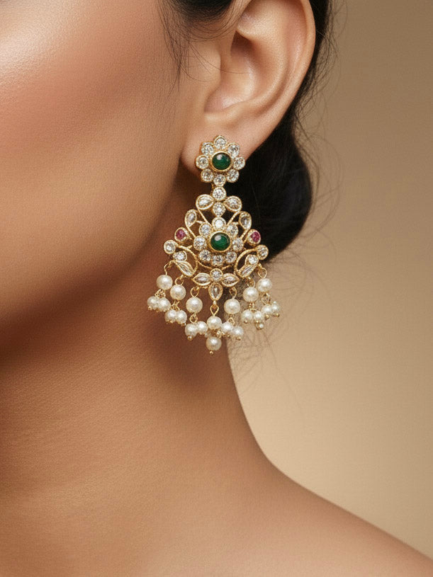Close-up of a woman wearing an ornate traditional collar jadau gold jewellery set and jadau earrings with pearls , Kundan, Green Color Stone. Saree look enhanced with a traditional Jadau artificial necklace. Bridal styling inspiration with a premium Jadau imitation necklace.