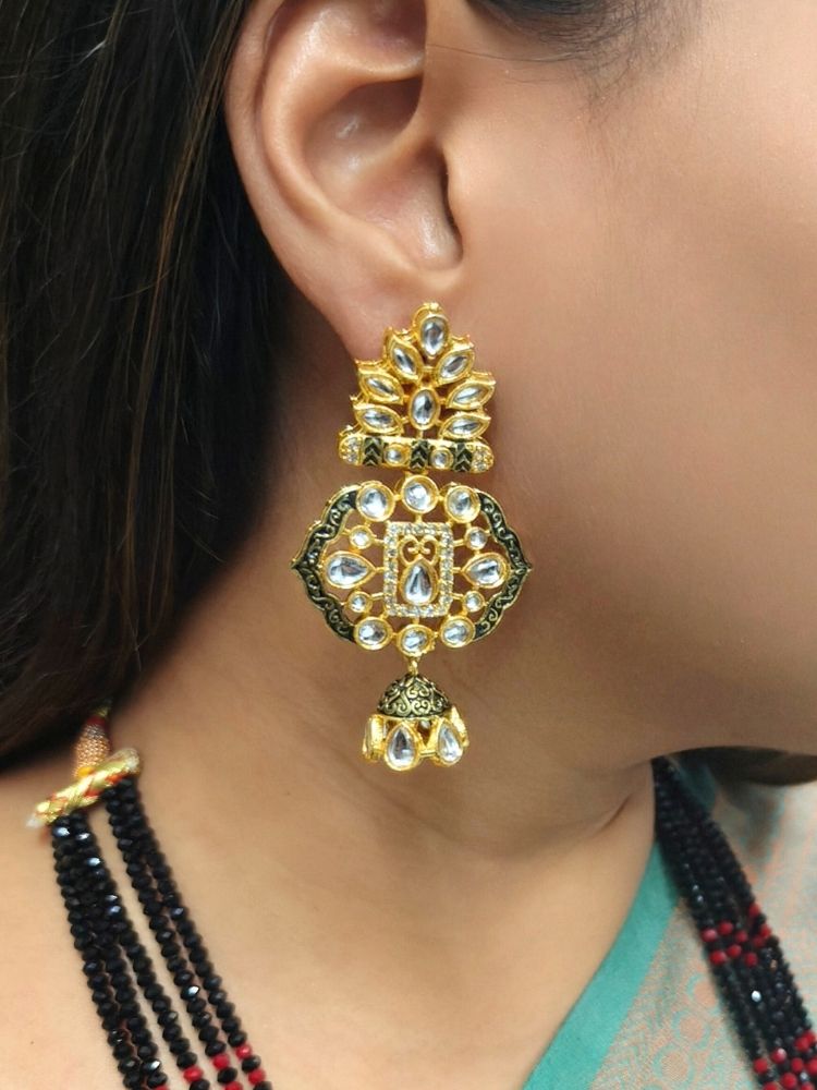 A woman in a traditional Sea Green and gold silk saree wears the Black Shazia Necklace Set with matching earrings and poses in profile with a smile—an elegant choice for a wedding ceremony. Kundan Meenakari pendant hanging with Black crystal stones, and pearls, perfect for weddings. 