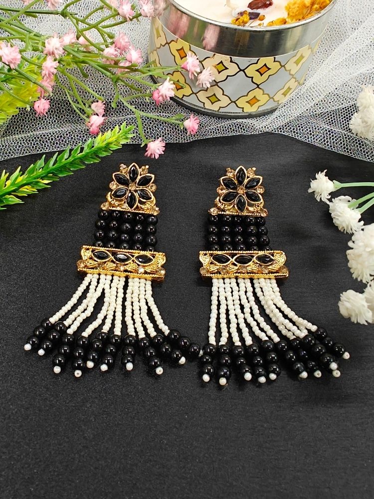 The Black Tripti Earrings are ornate gold earrings adorned with white pearls and crystal stones. Featuring long dangling pearl strands, they’re perfect for pairing with a wedding ceremony dress.