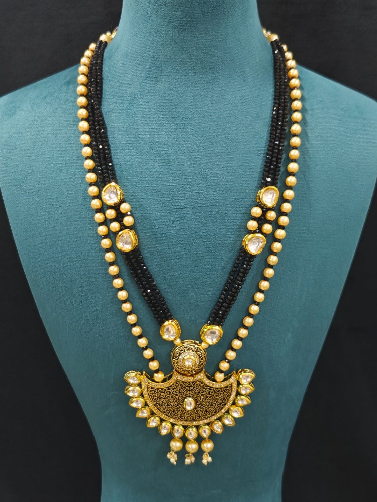 Close-up of an ornate traditional Black Meenakari Long  jewellery set and earrings with Kundan, Meenakari work, crystal beads, pearls and American Diamond. Mehendi ceremony look completed with a Meenakari jewelry set. A vibrant Meenakari artificial jewelry set for celebrations.