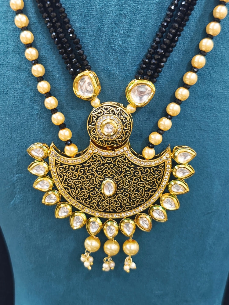 Close-up of an ornate traditional Black Meenakari Long  jewellery set and earrings with Kundan, Meenakari work, crystal beads, pearls and American Diamond. Mehendi ceremony look completed with a Meenakari jewelry set. A vibrant Meenakari artificial jewelry set for celebrations.