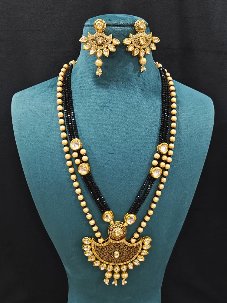 Close-up of an ornate traditional Black Meenakari Long  jewellery set and earrings with Kundan, Meenakari work, crystal beads, pearls and American Diamond. Mehendi ceremony look completed with a Meenakari jewelry set. A vibrant Meenakari artificial jewelry set for celebrations.