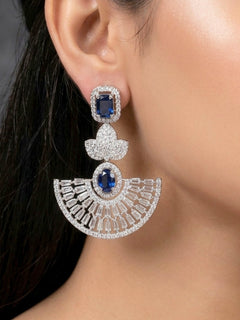 Close-up of a woman wearing an ornate Western (Silver Polish) Blue Diamond Earrings with American Diamond and Colored Stones. Reception-ready look featuring a statement American diamond Earrings set. Elegant wedding jewelry look featuring a premium artificial American diamond Earrings.