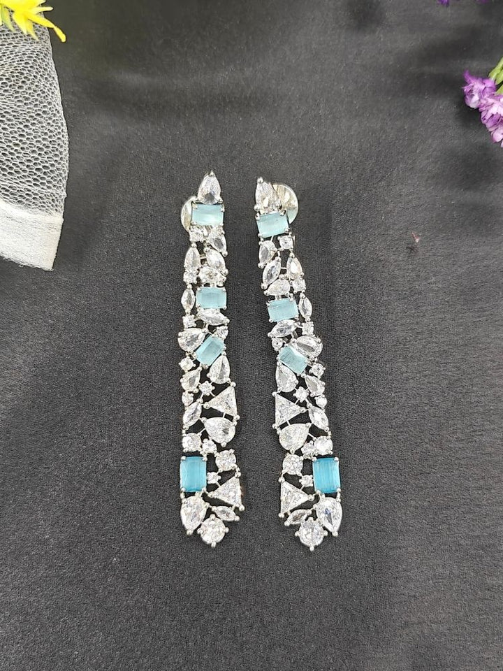 Close-up of an ornate Western Blue (Silver Polish) Diamond Earrings with American Diamond and Colored Stones. Close-up of American diamond earrings styled for a reception party. Cocktail party outfit paired with sparkling artificial American Diamond earrings.