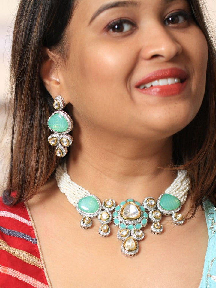 A woman in a  Red outfit smiles, showcasing the Peacoski Blue Tamanna Necklace Set and matching earrings. Her soft makeup highlights the elegance of this statement jewelry ensemble.