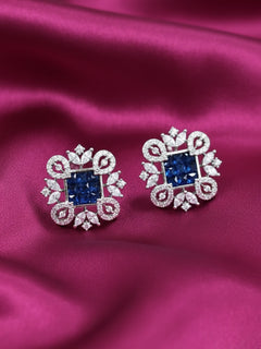 Close-up of an ornate Western (Silver Polish) Blue Diamond Studs Earrings with American Diamond. western dress styled with lightweight artificial American Diamond studs earrings. Wear in office and everyday.