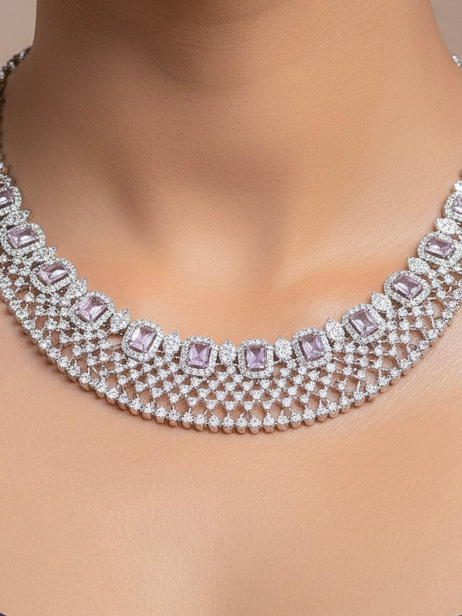Close-up of a woman wearing an ornate Western Lilac (Silver Polish) Collar Diamond jewellery set and earrings with American Diamond and Lilac Colored Stones. Model wearing a lightweight American diamond necklace perfect for long wedding functions. 