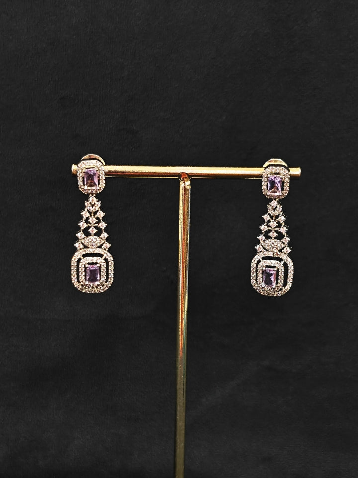 Close-up of an ornate Western Lilac (Silver Polish) Collar Diamond jewellery set and earrings with American Diamond and Lilac Colored Stones. A lightweight American diamond necklace perfect for long wedding functions. 