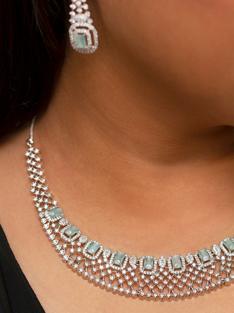 Close-up of a woman wearing a stunning affordable artificial diamond necklace with mint green colored stone and matching earrings set, perfect for wedding guests and formal events. This luxury artificial diamond jewelry provides the brilliance of real diamonds at a fraction of the cost.