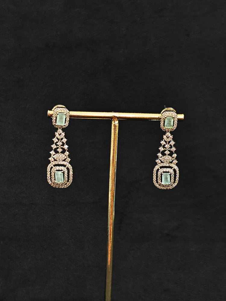 Close-up of an ornate Western Mint Green (Silver Polish) Collar Diamond jewellery set and earrings with American Diamond and Mint Green Colored Stones. A lightweight American diamond necklace perfect for long wedding functions. 
