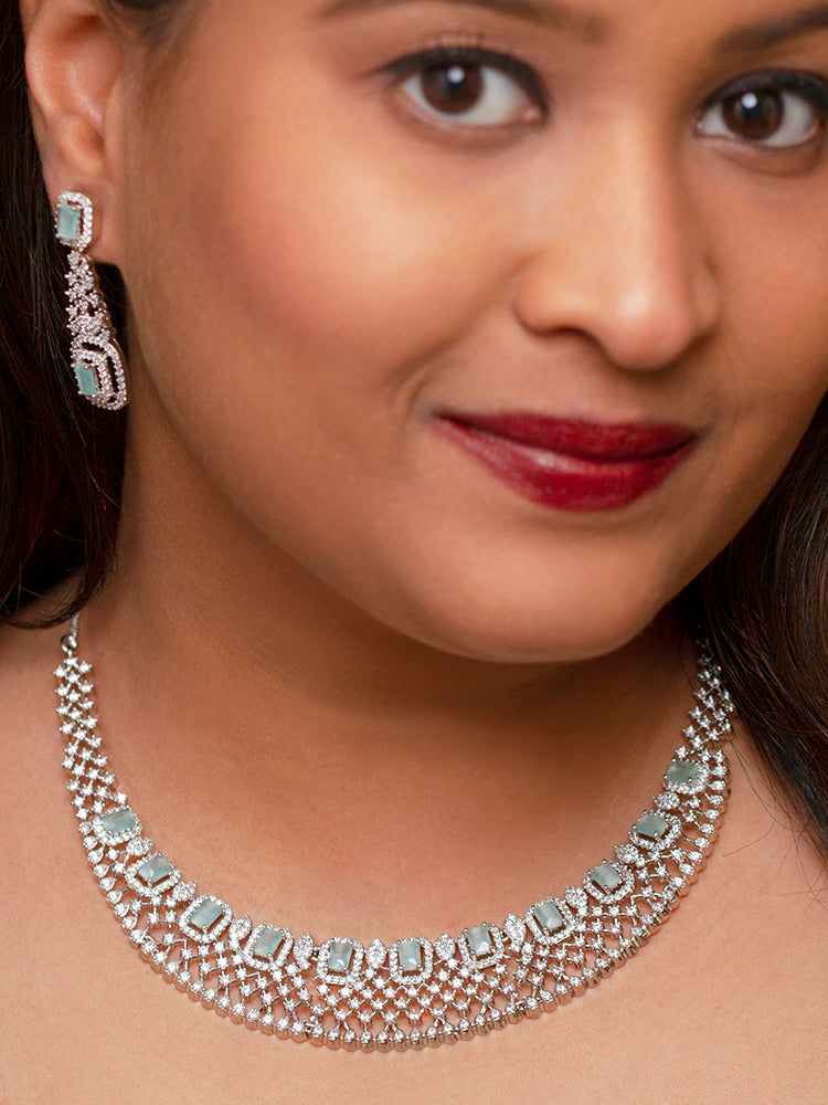 Elegant woman wearing a luxurious artificial diamond necklace with mint green colored stone and matching earrings, perfect for high-profile wedding receptions and formal galas. This high-end artificial diamond jewelry set combines style, elegance, and affordability for special occasions.