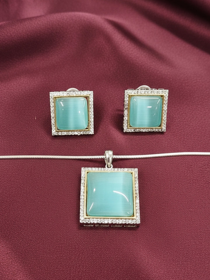 Close-up of an ornate traditional (Silver Polish) Blue Pendant set and earrings with American Diamond and Blue Colored Stone. Close-up of a cocktail party look featuring a premium Colored Stone Pendant Set. Party wear outfit completed with a lightweight Colored Stone Pendant Set.
