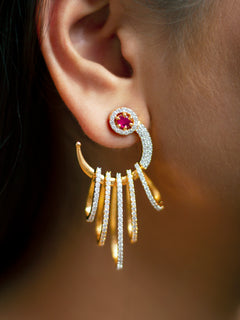 Close-up of a woman wearing an ornate Western (gold Polish) Red Diamond Earrings with American Diamond and Colored Stones. A woman wearing a luxury American diamond Earring styled beautifully for a wedding guest look in India. Close-up of a cocktail party look featuring a premium American diamond Earrings.
