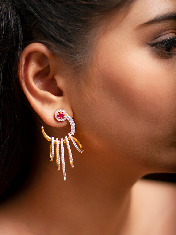Close-up of a woman wearing an ornate Western (gold Polish) Red Diamond Earrings with American Diamond and Colored Stones. A woman wearing a luxury American diamond Earring styled beautifully for a wedding guest look in India. Close-up of a cocktail party look featuring a premium American diamond Earrings.