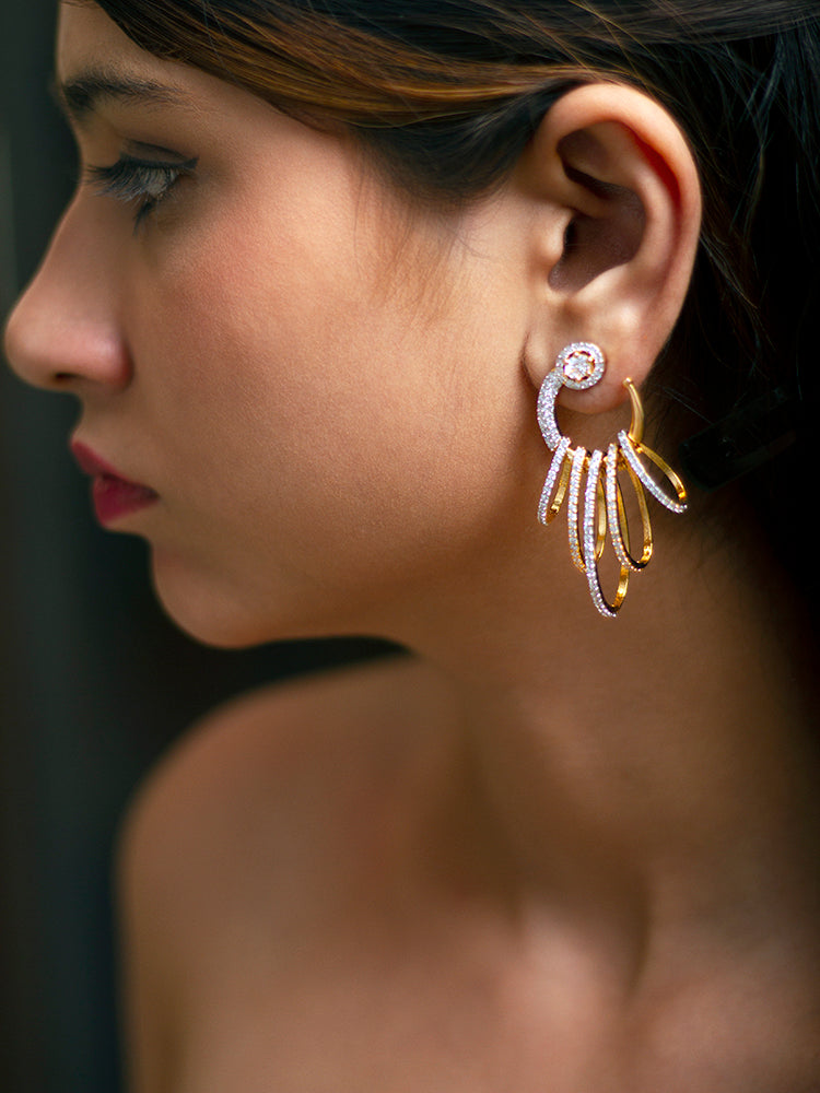 Close-up of a woman wearing an ornate Western (gold Polish) White Diamond Earrings with American Diamond and Colored Stones. A woman wearing a luxury American diamond Earring styled beautifully for a wedding guest look in India. Close-up of a cocktail party look featuring a premium American diamond Earrings.