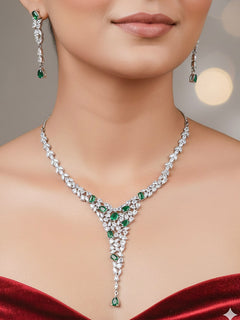 Close-up of a woman wearing a diamond and emerald necklace with green colored stone and  matching earrings. This premium artificial diamond jewelry set is perfect for special occasions, from Indian weddings to engagement parties, offering sophisticated glamour without the high price tag.