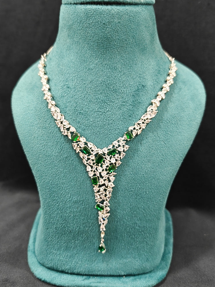 Close-up of a diamond and emerald necklace with green colored stone and  matching earrings. This premium artificial diamond jewelry set is perfect for special occasions, from Indian weddings to engagement parties, offering sophisticated glamour without the high price tag.