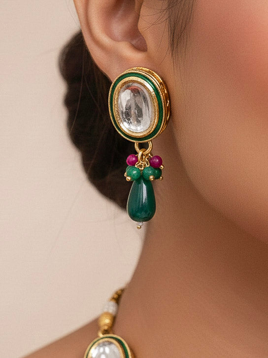 Close-up of a woman wearing an ornate traditional (Gold Polish) Dark Green Collar jewellery set and earrings with Kundan, Red and Green small beads and Tumble Stone. Mehendi ceremony look completed with a handcrafted Kundan jewelry set. Festive saree styling with a premium artificial Kundan necklace. Perfect Necklace for Wedding Function and Festive.