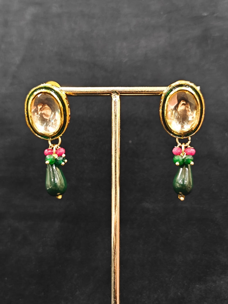 Close-up of an ornate traditional (Gold Polish) Dark Green Collar jewellery set and earrings with Kundan, Red and Green small beads and Tumble Stone. Mehendi ceremony look completed with a handcrafted Kundan jewelry set. Festive saree styling with a premium artificial Kundan necklace. Perfect Necklace for Wedding Function and Festive.