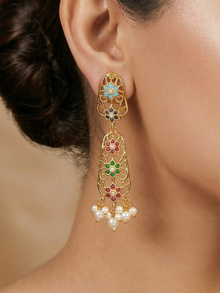 Close-up of a woman wearing an ornate traditional Navratan jadau gold jewellery set and jadau earrings with navratan color stone and Pearls. Woman pairing a traditional Jadau necklace with a silk saree. Woman wearing a royal Jadau necklace for festive events in India.