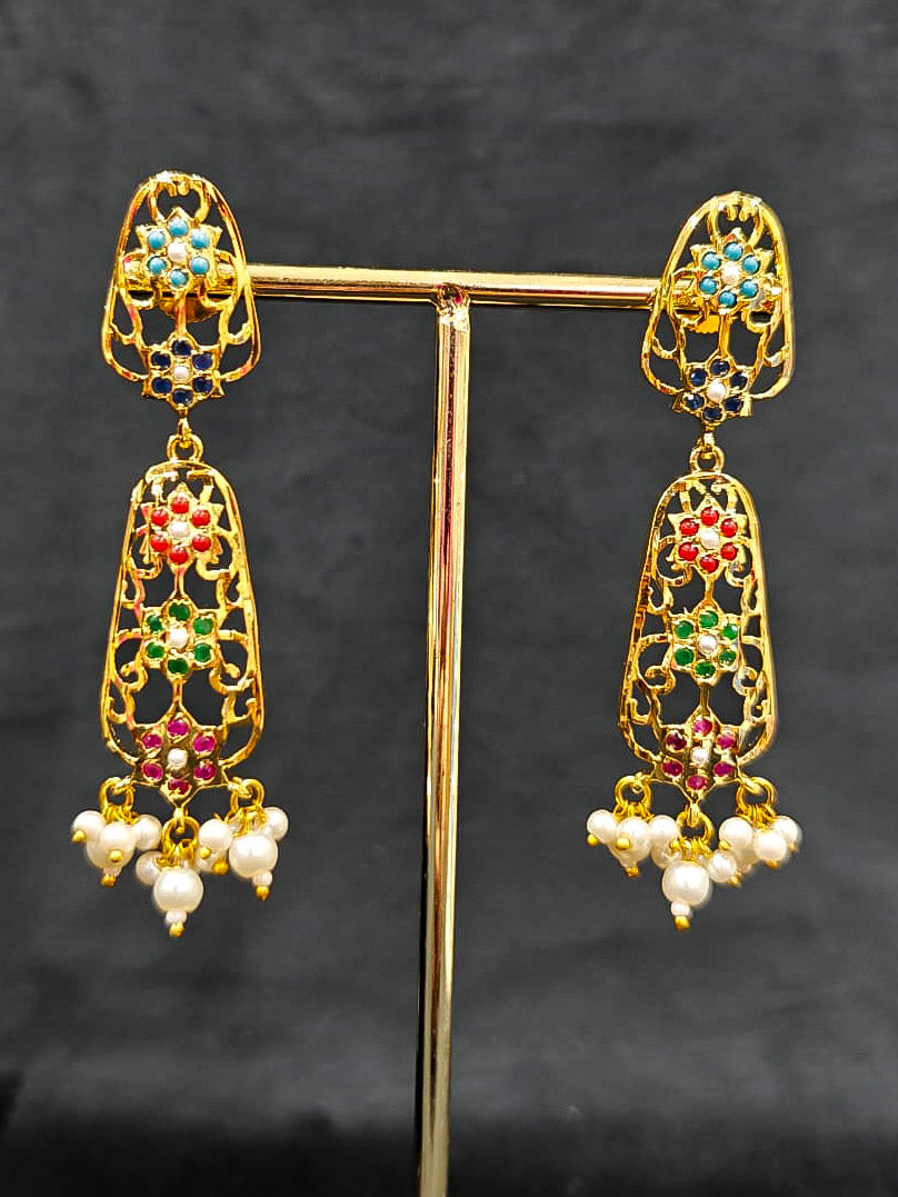Close-up of an ornate traditional Navratan jadau gold jewellery set and jadau earrings with navratan color stone and Pearls. Close-up of intricate Jadau detailing in artificial jewelry. A royal Jadau necklace for festive events in India.