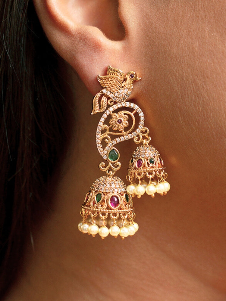 Close-up of a woman wearing an ornate traditional (gold Polish) Diamond Earrings with American Diamond, colored Stones and Pearls. Saree styling inspiration featuring elegant imitation American Diamond earrings. Woman wearing trendy artificial earrings for a 2026 wedding celebration in India.