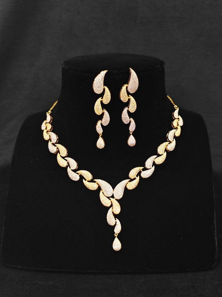 Close-up of a sparkling artificial leaf designer diamond necklace and diamond earrings set, designed to offer a radiant, elegant look for any formal occasion or Indian wedding. This affordable diamond jewelry provides a flawless, luxurious alternative to natural diamonds.