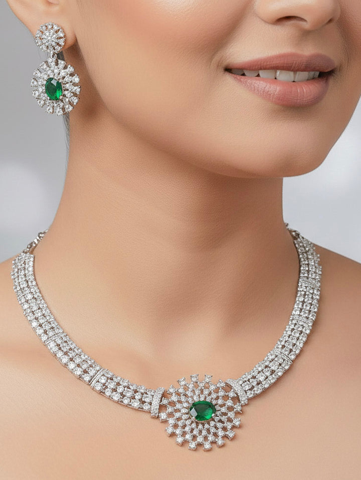 A woman showcasing a beautiful artificial diamond necklace with emerald green colored stone and earrings set, ideal for festivals, family gatherings, and special celebrations in India. This elegant diamond jewelry provides the perfect blend of sparkle and tradition, with a modern twist.