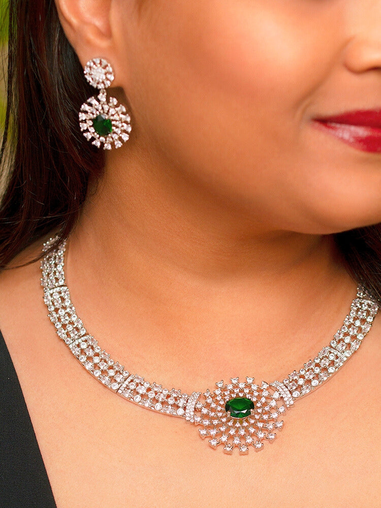 A beautiful woman wearing an elegant artificial diamond necklace with emerald green colored stone and matching earrings. This premium artificial diamond jewelry set is perfect for special occasions, from Indian weddings to engagement parties, offering sophisticated glamour without the high price tag.