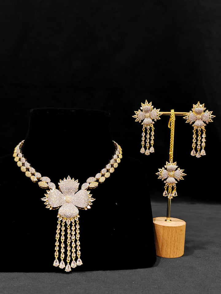 A glamorous artificial diamond necklace paired with chic earrings and maangtikka, perfect for bridal wear. This high-quality artificial diamond jewelry set. Close-up of a cocktail party look featuring a premium American diamond necklace.